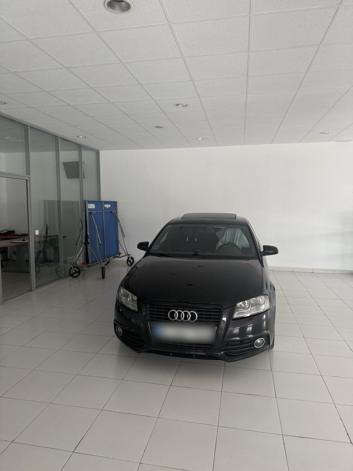 Audi A3 negro aparcado dentro de la nave
