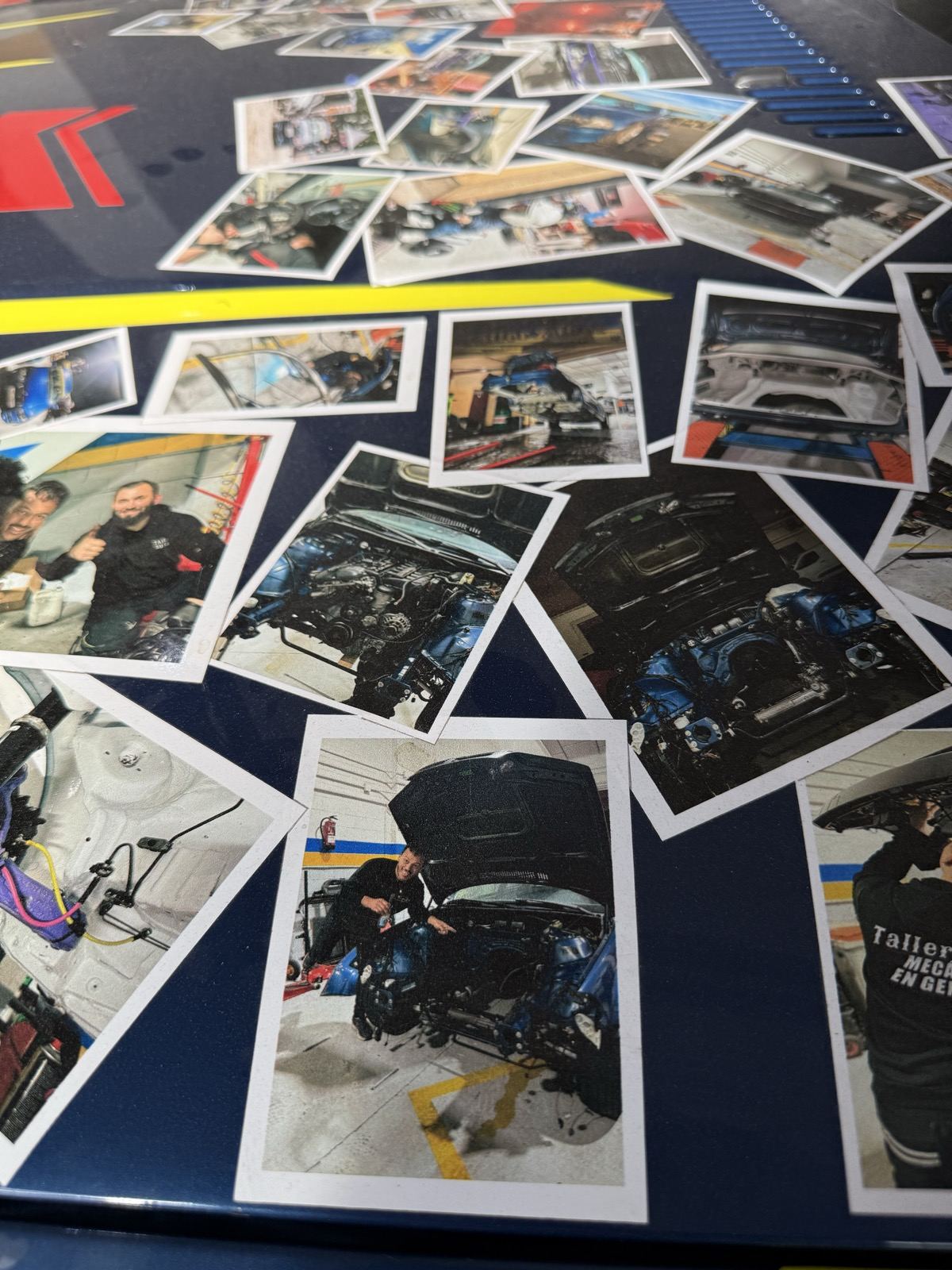 Pared del taller cubierta de fotos impresas de motores y coches preparados