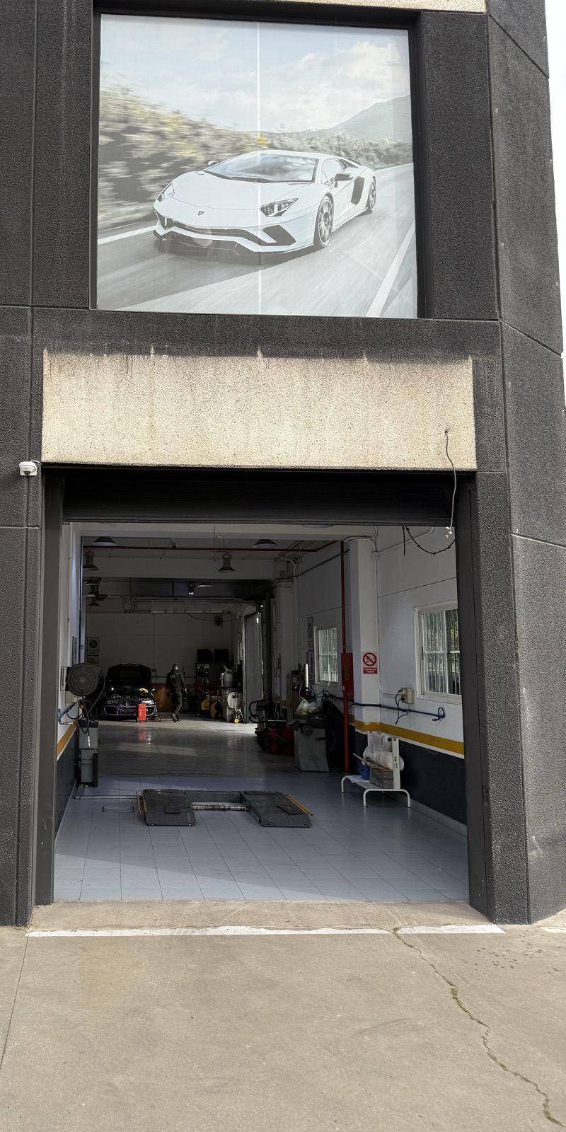 Entrada del taller con la puerta abierta y un elevador al fondo